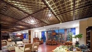 A spacious lobby with wooden furniture, a central decorative table, and a patterned ceiling. - Floral Hotel · YunFu City King Royal Hotel (Yunfu)