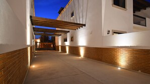 A corridor with a wooden pergola, brick walls, and a white building with windows and a door. - Gated 3BD+Office/flex bedroom, Sleeps 8, HTD Pool, Rooftop, 2 Blks to Malecon (La Paz)