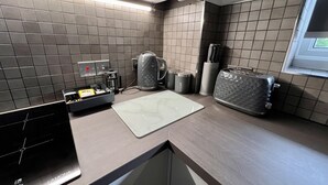 Una cocina moderna con estufa a gas, cafetera, tostadora y recipientes de almacenamiento.