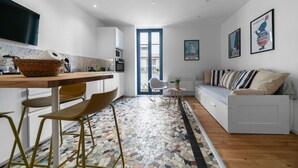 Una cocina moderna con comedor, sofá y suelo estampado.