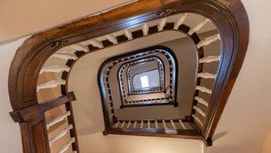 A wooden spiral staircase with white balusters and a light fixture at the top. - Superbe appartement centre-ville avec terrasse (Vichy)