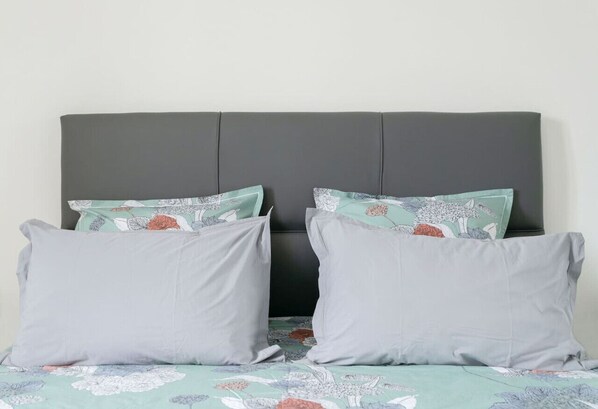 A bed with a grey headboard and floral-patterned bedding. - Superbe appartement centre-ville avec terrasse (Vichy)