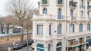 A multi-story building with a classical architectural style, featuring balconies and a central dome. - Superbe appartement centre-ville avec terrasse (Vichy)