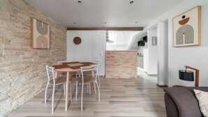 A modern interior with a dining area, kitchen, and living space. - Charmant 2 pièces Centre Ville (Vichy)