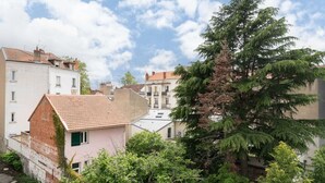 Un quartiere residenziale con edifici, un albero grande e cielo sereno.