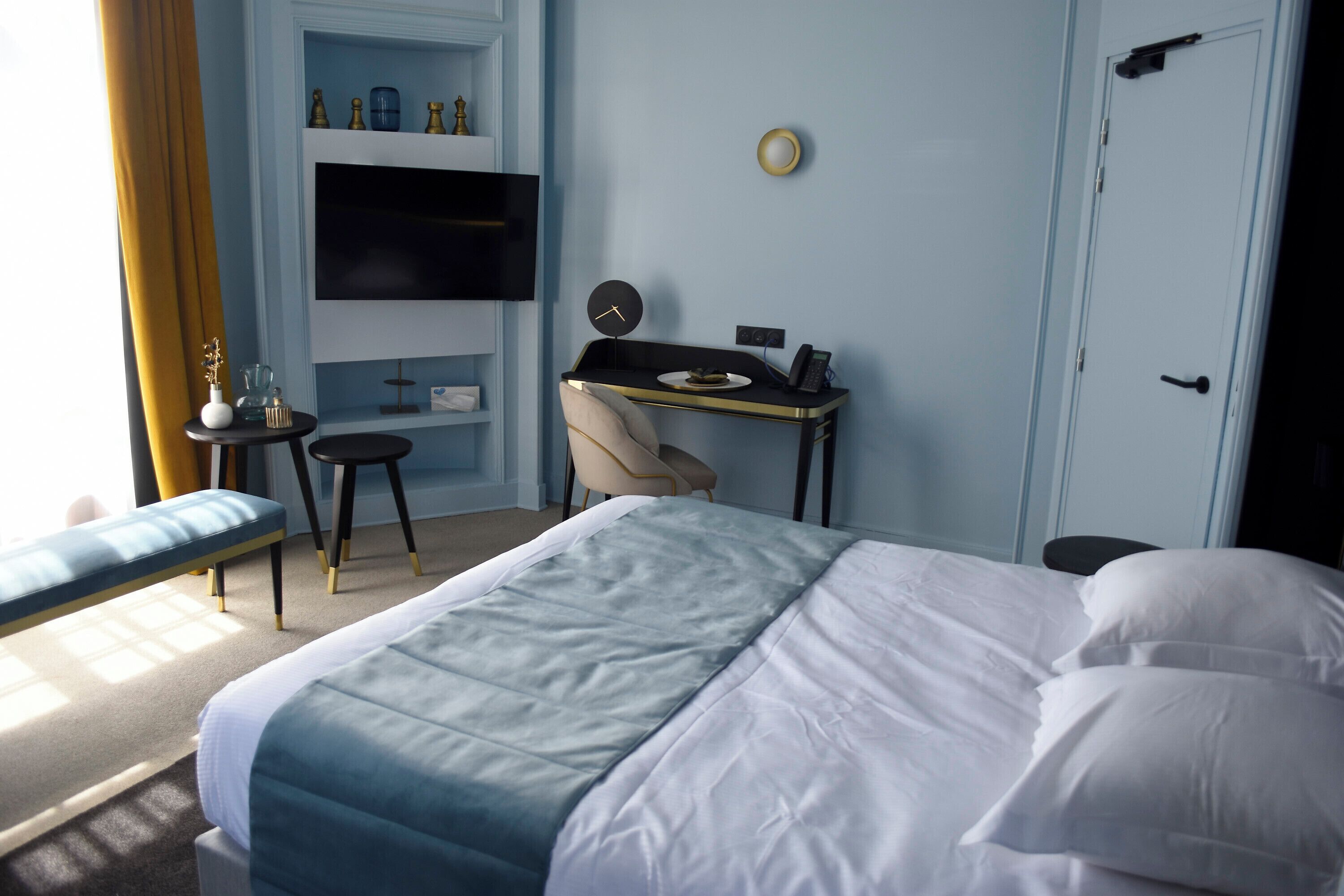 Ein Schlafzimmer mit Bett, Schreibtisch, Stuhl und Fernseher.