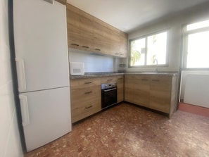 Une cuisine avec des meubles en bois, un four encastré et un four à micro-ondes.