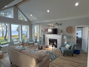 A spacious living room with a fireplace, large windows, and a view of the sea. - Fabulous Beach House on Elliott Island -beautiful sandy beach, tranquil 6 acres (Vienna)