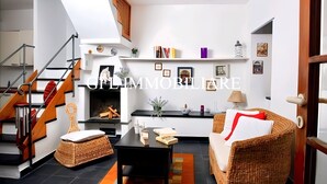 Un salon moderne avec un escalier, une cheminée et un canapé.