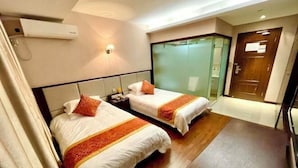 A hotel room with two beds, a desk, a nightstand, a wall-mounted air conditioner, and a sliding glass door closet. - Leinuobinguna (Yueqing)