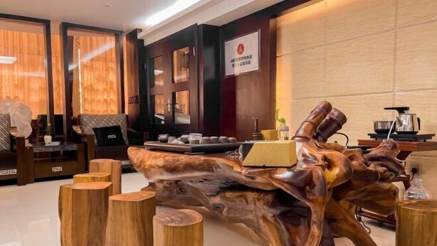 A modern interior with a wooden art piece, seating, and a sign on the wall. - Leinuobinguna (Yueqing)