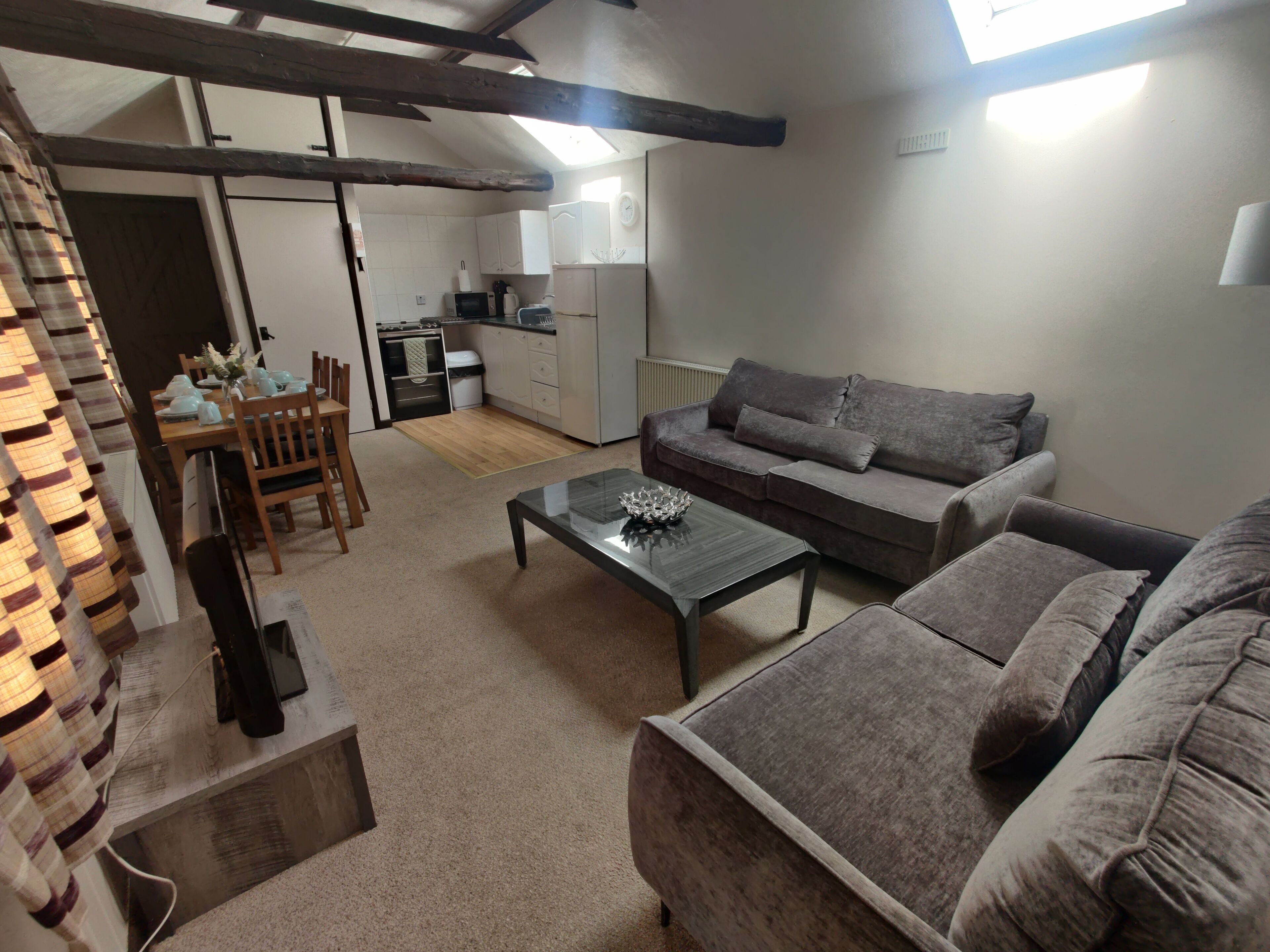 Ein gemütliches Wohnzimmer mit einer Couch, einem Couchtisch und einem Essbereich mit Stühlen und einem Tisch.
