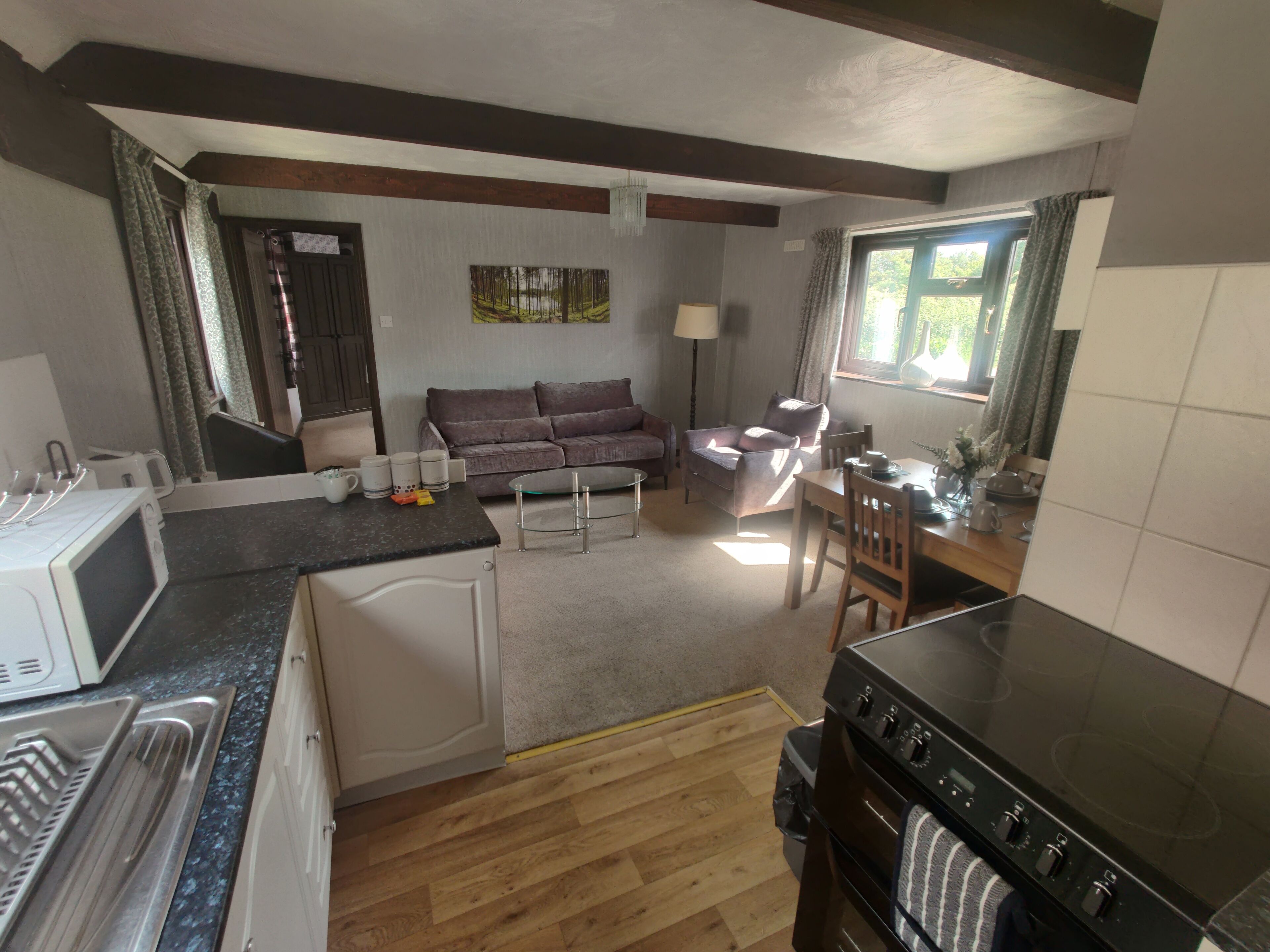 A compact kitchen with a microwave, stove, and dining area.