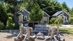 Un chalet rustique doté d’un porche, entouré d’une forêt dense.