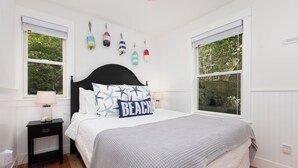 Une chambre à coucher avec un lit, des tables de chevet et des objets décoratifs accrochés au mur.