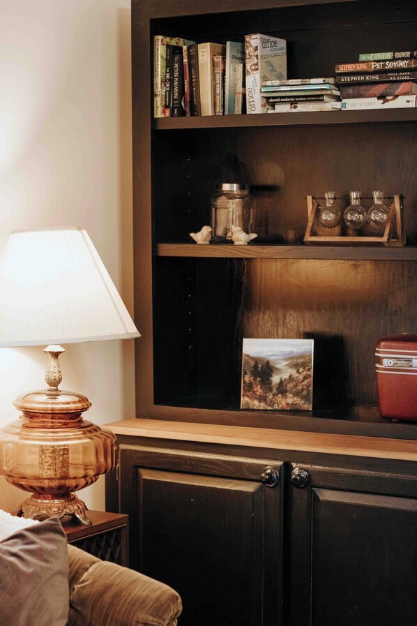 A bookshelf with books, a vintage radio, and decorative items.