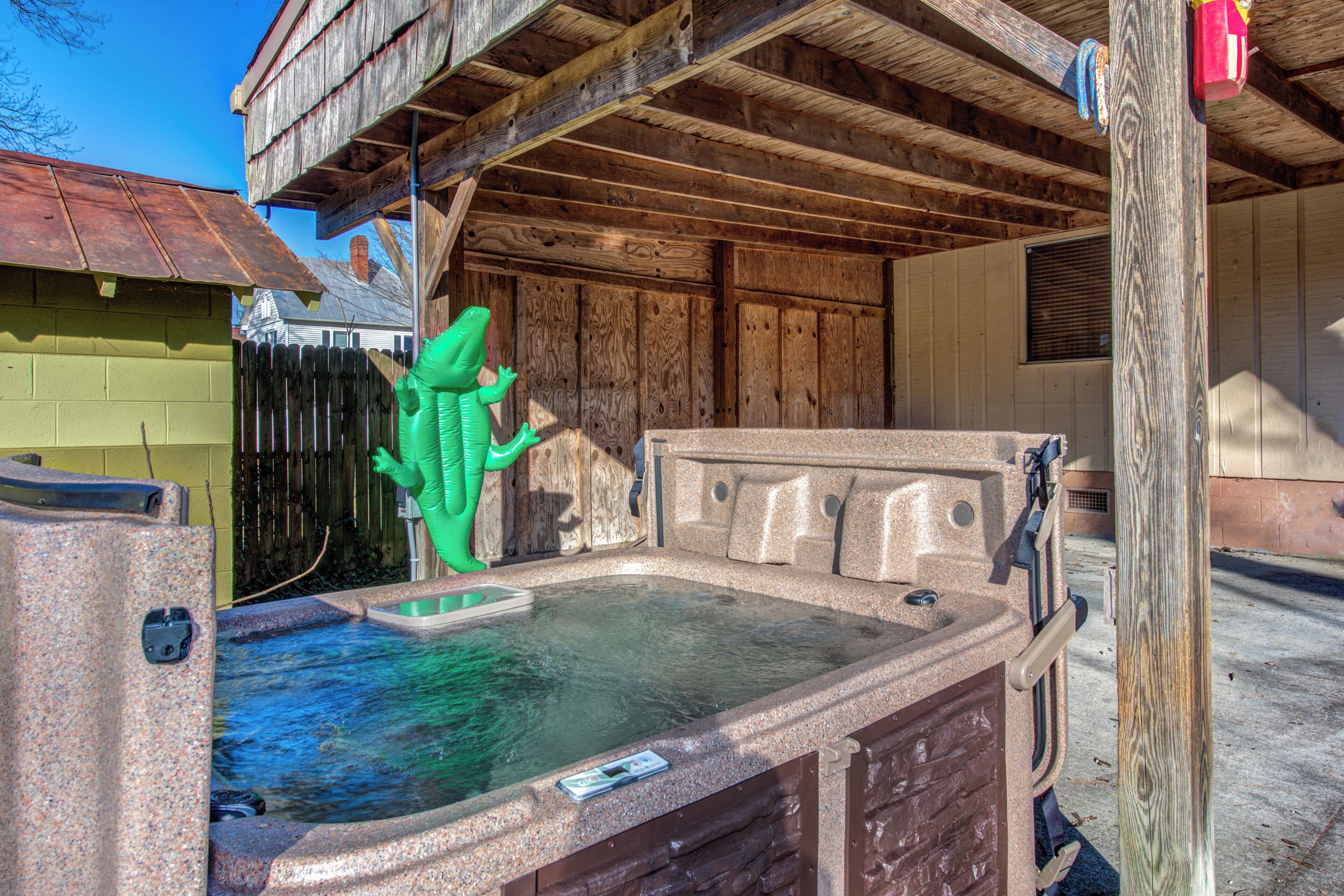 Un bain à remous avec une terrasse en bois et une clôture en bois en arrière-plan.