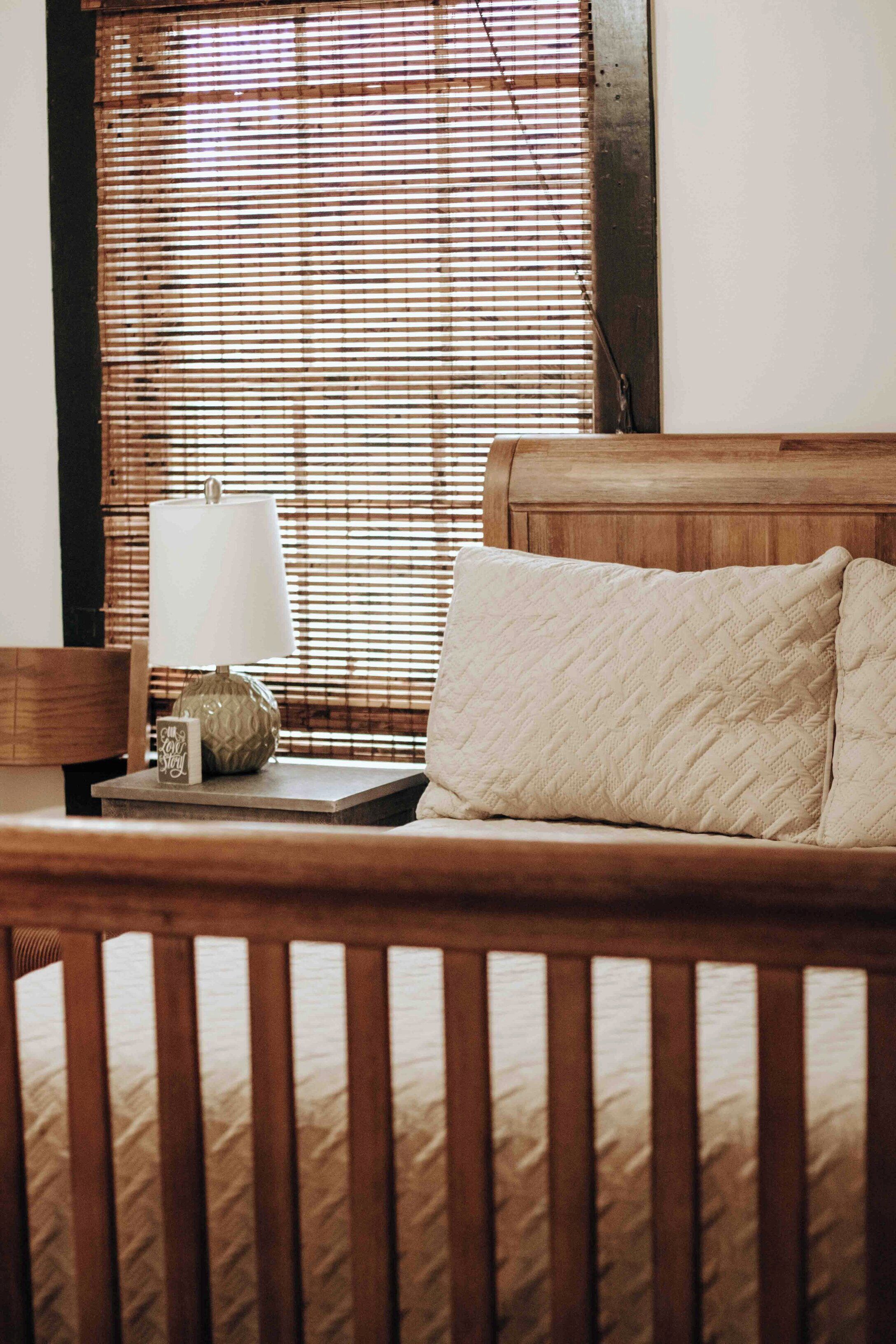 A wooden bed with a headboard, a bedside table with a lamp, and a decorative item.