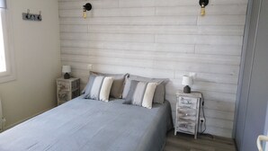 A bedroom with a bed, two bedside tables, and a wall-mounted light fixture. - Le Figuier, Gite Rural du Seuil, Near La Rochelle (Villedoux)