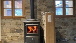 A wood-burning stove with a stone wall and windows. - Balcony, fireplace or stove, tv, 88m², Pralognan-la-Vanoise (Pralognan-la-Vanoise)