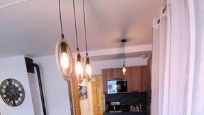 Ein moderner Essbereich mit einem Holztisch, schwarzen Stühlen und einem gewebten Korb in der Mitte.