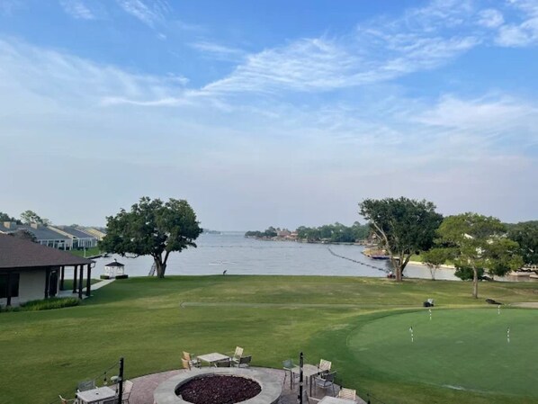 A golf course with a water body in the background, a pavilion, and a well-maintained lawn. - Golf Course Views + Treehouse Vibes (Montgomery)