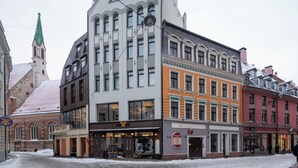 Un edificio a più piani con un insieme di stili architettonici, tra cui una torre imponente con guglia.