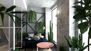 Ein modernes Wohnzimmer mit einer Couch, einem Couchtisch und verschiedenen Pflanzen.