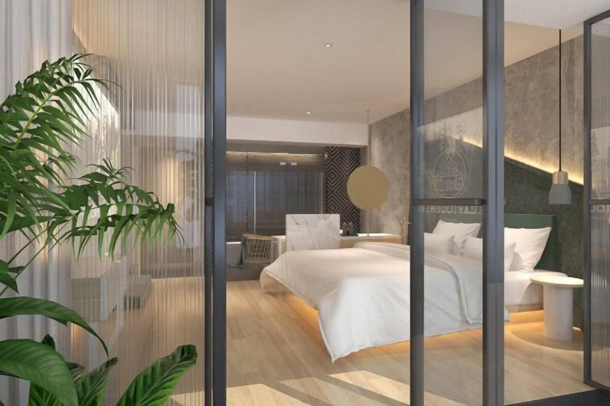 Ein modernes Schlafzimmer mit einem großen Bett, einem Nachttisch und einer Zimmerpflanze.