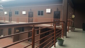 A building with multiple rooms, a staircase, and a railing. - Masterpiece 1 bedroom  (Accra)