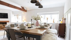 A dining area with a wooden table, chairs, and a hanging light fixture. - The Barn, Chipping Norton (Chipping Norton)