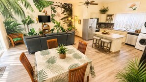 A living room with a sofa, dining table, chairs, and a kitchen area with a refrigerator and sink. - KONA CLOUD FOREST GUEST HOUSE~3 Bedrooms~ (Kailua-Kona)
