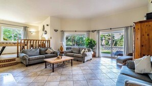 A spacious living room with two sofas, a coffee table, and a wooden cabinet. - Villa Concha by Indigo (Carvoeiro)