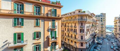 Un edificio de varios pisos con balcones, estacionamiento y vista despejada al mar.