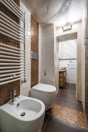 A bathroom with a white sink, a toilet, and a shower area. - XVI Charm Apartment by Wonderful Italy (Bologna)