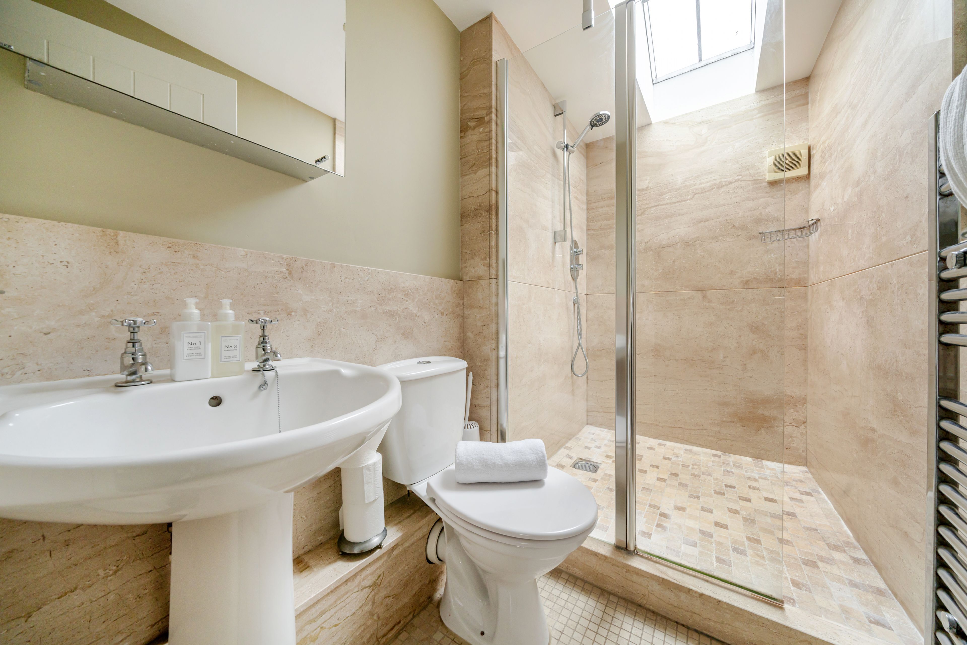 Une salle de bain avec un lavabo, des toilettes et une douche.