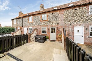 Classic facade with a traditional brick exterior, wooden fence, and covered outdoor seating area.