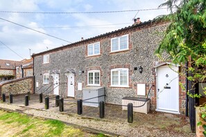 Traditional stone house with a classic design, featuring a symmetrical facade and a central door.