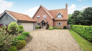 A two-story house with a gravel driveway and a well-maintained garden. - Cherry House - sleeps 8 guests  in 4 bedrooms (Thornham)