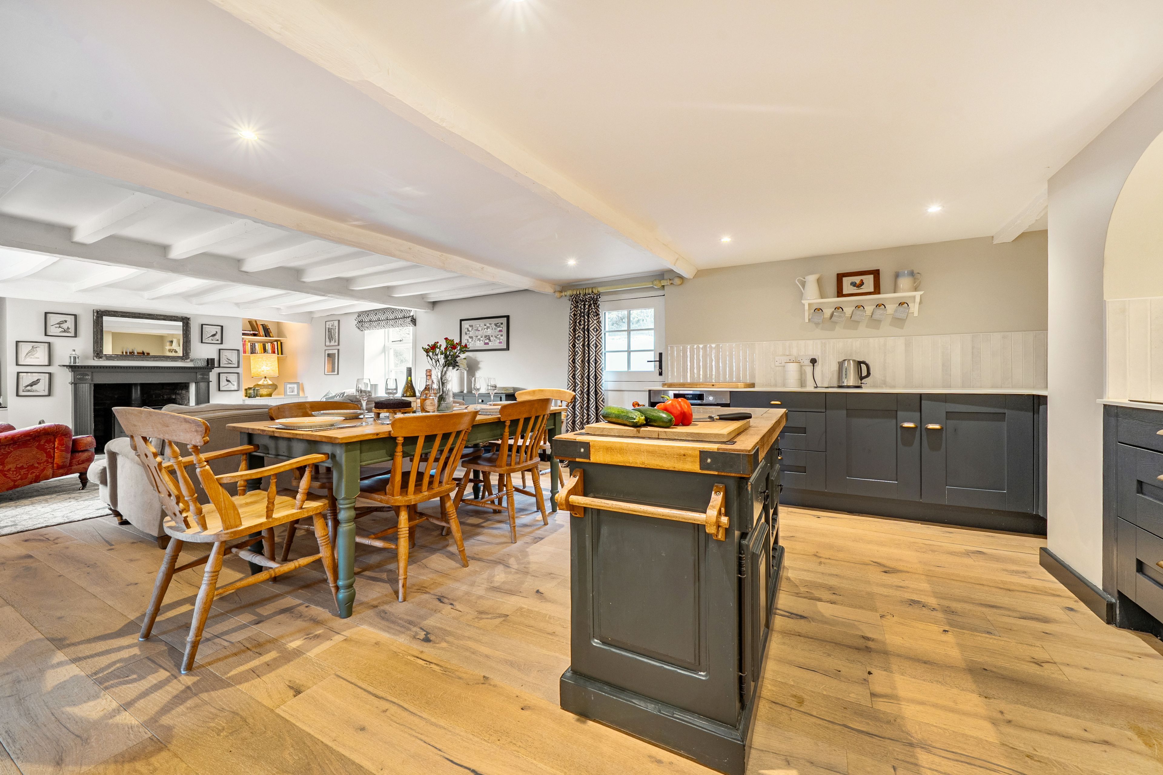A spacious living area with a dining table, chairs, and a fireplace.