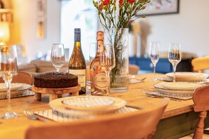 A dining table set with plates, cutlery, wine glasses, and bottles, suggesting a formal dining arrangement. - Cherryhill - sleeps 5 guests  in 3 bedrooms (North Creake)