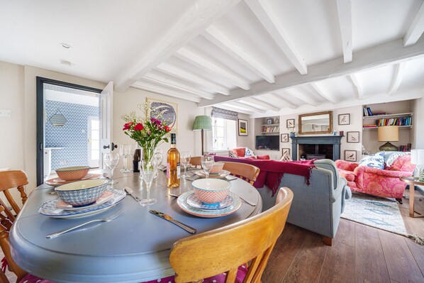 Enjoy meals with family and friends in this inviting dining area, featuring a round table, comfortable seating, and a fireplace.