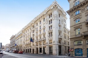 A historic building with ornate architecture, multiple floors, and a prominent entrance. - Dream Suite Trevi (Rome)