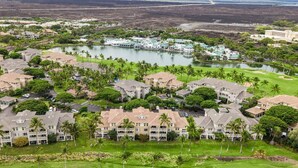 Un complejo turístico con varias edificaciones, un campo de golf y un lago.