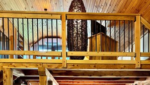 Ein Holzinterieur mit Küche, Essbereich und Wohnzimmer mit Sofa und Sesseln.