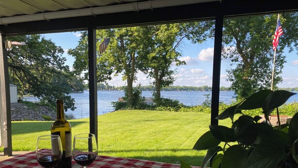 Ein Tisch mit kariertem Tuch, einer Weinflasche und zwei Weingläsern.