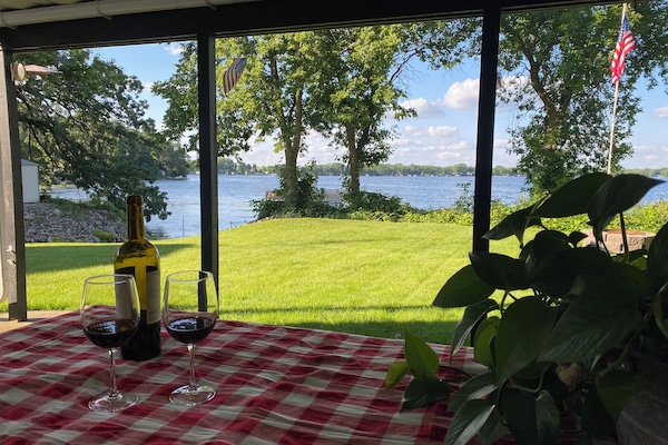 Large picnic table under the deck on a concrete patio.