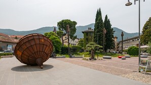 A public square with a large, metallic sculpture, paved walkways, and surrounding buildings. - Angelina s House in Iseo (Iseo)