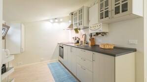 A modern kitchen with light-colored cabinets, a black countertop, and a built-in stove. - Angelina s House in Iseo (Iseo)