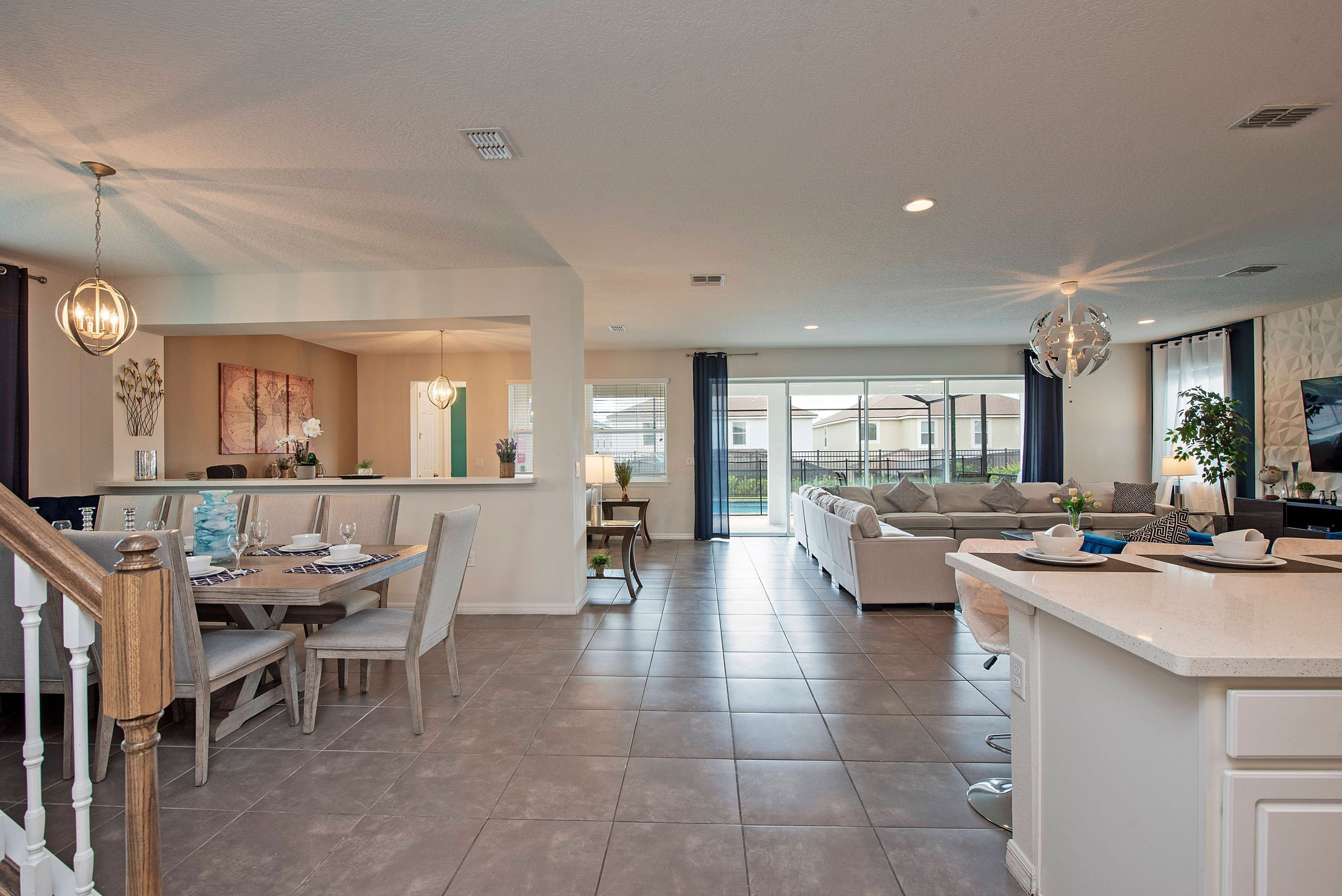 A spacious living area with a dining table, sofas, and a kitchen island.